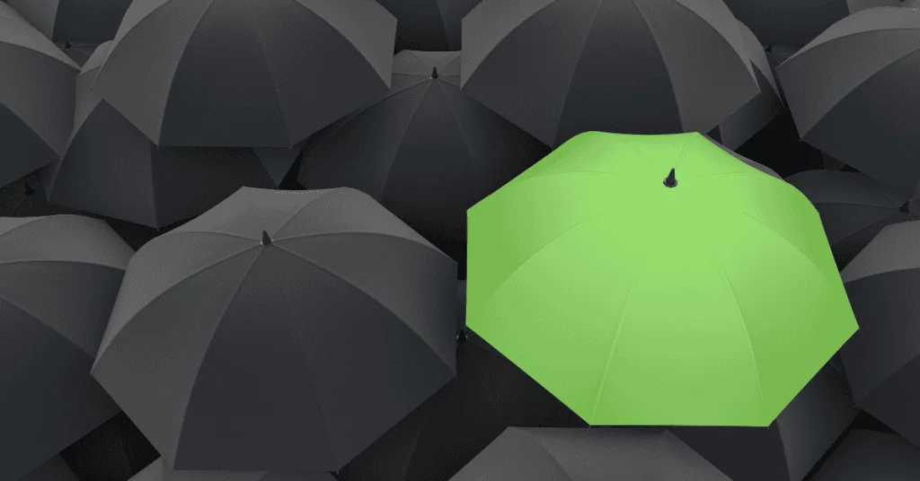 Green Umbrella in sea of Black Umbrellas