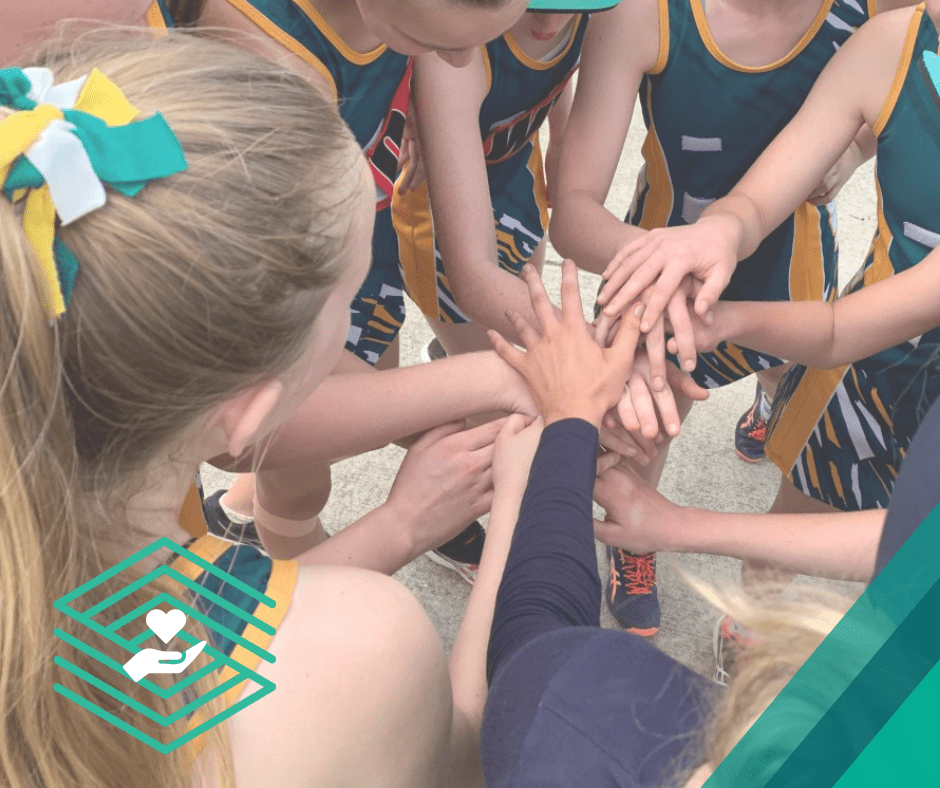 Empowering young women Young Ranger Netball players putting their hands in as a sport team. 