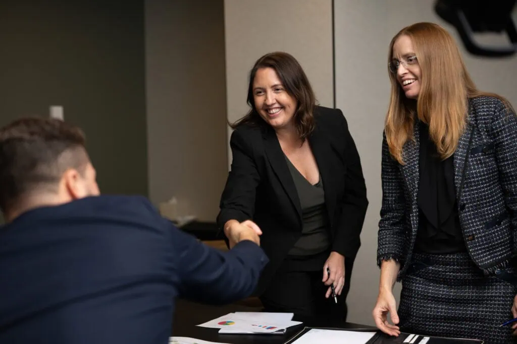 Kelly Hill and Alethea Rose, Directors of q4 financial thanking a client.