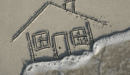 House drawn in sand with waves